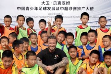 David Beckham posa con escolares en el Nanjing Olympic Sports Center donde los alumnos tuvieron el privilegio de poder enseñarle sus habilidades con el esférico. Aunque el futbolista de 37 años tampoco se quedó atrás y no pudo aguantar la tentación de jugar un rato con ellos.