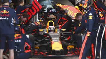 Red Bull's Australian driver Daniel Ricciardo sits in his team garage as mechanics work on his car during the Formula One Australian Grand Prix on March 26, 2017. / AFP PHOTO / POOL / BRANDON MALONE / --IMAGE RESTRICTED TO EDITORIAL USE - STRICTLY NO COMMERCIAL USE--