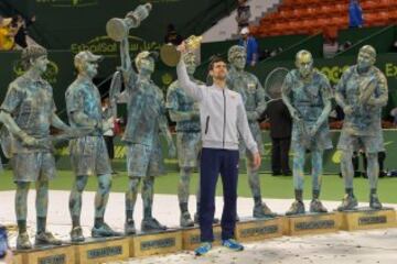 Novak Djokovic celebra alzando su trofeo delante de las estatuas de los participantes e imitando a su propia estatua.