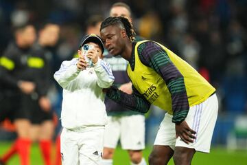 Camavinga se fotografía, durante el calentamiento del Clásico, con un niño que saltó al campo.