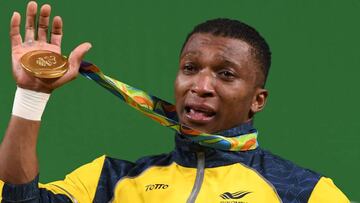 Colombia&#039;s Oscar Albeiro Figueroa Mosquera poses with his gold medal on the podium of the Men&#039;s 62kg weightlifting competition at the Rio 2016 Olympic Games in Rio de Janeiro on August 8, 2016.  / AFP PHOTO / GOH Chai Hin