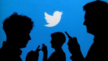 FILE PHOTO: FILE PHOTO: People holding mobile phones are silhouetted against a backdrop projected with the Twitter logo in this illustration picture taken September 27, 2013. REUTERS/Kacper Pempel/Illustration/File Photo/File Photo