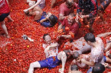 Revelers enjoy as they throw tomatoes at each other, during the annual "Tomatina", tomato fight fiesta, in the village of Bunol, 50 kilometers outside Valencia, Spain, Wednesday, Aug. 30, 2017. At the annual "Tomatina" battle, that has become a major tourist attraction, trucks dumped 160 tons of tomatoes for some 20,000 participants, many from abroad, to throw during the hour-long Wednesday morning festivities. (AP Photo/Alberto Saiz)