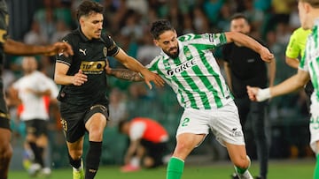 SEVILLA, 23/05/2025.- El centrocampista del Betis Isco Alarcón (d) juega un balón ante André Almeida, del Valencia, durante el partido de la última jornada de LaLiga de fútbol que Real Betis y Valencia CF disputan este viernes en el estadio Benito Villamarín, en Sevilla. EFE/Julio Muñoz