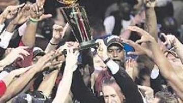 <b>TODOS QUERÍAN TOCARLA. </b>Riley encabeza la alegría de los Heat, que lograron su primer título.