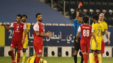 Singaporean referee Muhammad Taqi (4th-R) presents a red card to a Persepolis player during the AFC Champions League semi-finals match between Saudi&#039;s Al-Nassr and Iran&#039;s Persepolis on October 3, 2020, at the Jassim Bin Hamad Stadium in the Qata