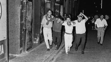 Personas trasladan aun herido durante las festividades de San Fermín en Pamplona, ​​​​España, en 1968.