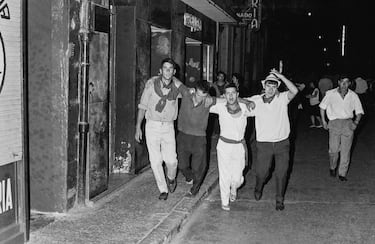 Personas trasladan aun herido durante las festividades de San Fermín en Pamplona, ​​​​España, en 1968.