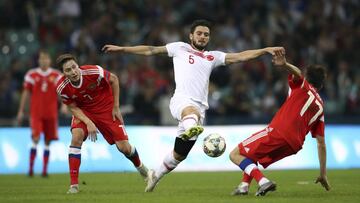 Okay Yokusluy pugna con la selección de Turquía por un balón en un amistoso contra Rusia.