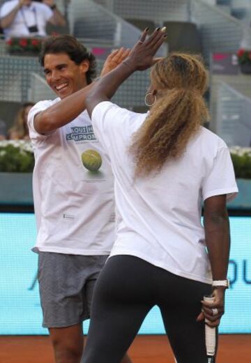  El tenista Rafa Nadal (i) choca la mano con la tenista Serena Williams, durante uno de los partidos benéficos del 'Charity Day' previo al Mutua Madrid Open de Tenis 2014.