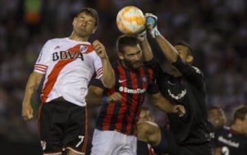 El jugador de River Plate Rodrigo Mora (i) disputa el balón con Martín Cauteruccio (c) y Sebastian Torrico (d) de San Lorenzo en el partido de ida de la final de la Recopa Sudamericana.