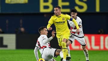 VILLARREAL (CASTELLÓN), 18/12/2024.- El centrocampista del Villarreal Yeremy Pino (c) escapa de Óscar Trejo (i), del Rayo, durante el partido de LaLiga que Villarreal CF y Rayo Vallecano disputan este miércoles en el estadio de La Cerámica. EFE/Andreu Esteban