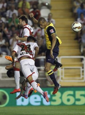 El defensa brasileño del Atlético de Madrid Joao Miranda disputa un balón con el centrocampista del Rayo Vallecano Alberto Bueno.