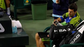 El tenista alemán Philipp Kohlschreiber (izq) y el serbio Novak Djokovic (dcha) esperan a que cese la lluvia durante un partido del torneo de Indian Wells disputado este lunes en Indian Wells