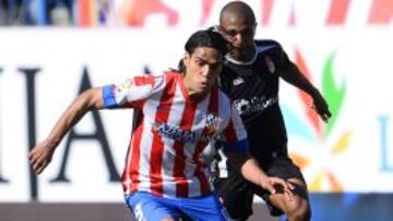 Atletico Madrid&#039;s Colombian forward Radamel Falcao (L) vies with Granada&#039;s Cameroonian defender Allan Nyom during the Spanish league football match Atletico de Madrid vs Granada on April 14, 2013 at Vicente Calderon stadium in Madrid. AFP PHOTO/ PIERRE-PHILIPPE MARCOU