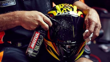 Una persona limpia la visera de un casco de moto.