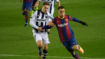 Levante's Spanish forward Jorge de Frutos (L) challenges Barcelona's US defender Sergino Dest during the Spanish league football match between FC Barcelona and Levante UD at the Camp Nou stadium in Barcelona on December 13, 2020. (Photo by LLUI