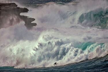 Un surfista monta una gran ola en Bondi Beach (Sídney) bajo un espeso manto de nubes, sin que parezca preocuparle en absoluto el panorama que se observa a su alrededor, donde se pueden apreciar los fuertes oleajes y vientos que azotan la costa este de Australia. Una fotografía de una belleza como solamente la naturaleza puede proporcionar.