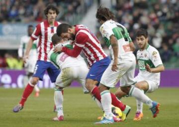 Arda Turan intenta llevarse el balón ante la defensa del Elche.