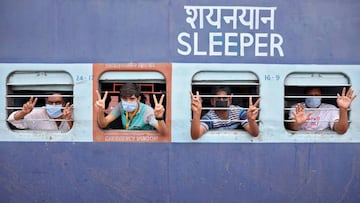 Migrant workers and pilgrims, who were stranded in the western state of Rajasthan due to a lockdown imposed by the government to prevent the spread of coronavirus disease, gesture from inside a train upon their arrival in their home state of eastern West 