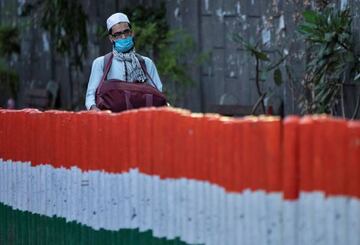 A man wearing a protective mask walks to board a bus that will take him to a quarantine facility, amid concerns about the spread of coronavirus, in the Nizamuddin area of New Delhi.