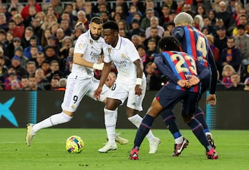 Vinicius lleva el balón ante la mirada de Benzema.