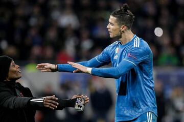 Cristiano Ronaldo deals with a pitch intruder during the Lyon-Juventus game.