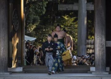 Los campeones de sumo entran en el santuario Meiji para interpretar la tradicional ceremonia de Año Nuevo, en Tokio (Japón). La ceremonia tradicional atrae cada año a miles de personas que no quieren perderse la lucha entre los dos campeones de sumo de Japón, conocidos como yokozuna, considerada como una ofrenda a los dioses sintoístas. 