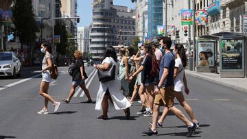 GRAF7952. MADRID, 01/08/2020.- Varias personas con mascarillas caminan por Gran Vía en Madrid este sábado durante la ola de calor. La Agencia Estatal de Meteorología (Aemet) mantiene una treintena de provincias de diez comunidades autónomas en alerta por calor, en nivel naranja -riesgo importante- amplias zonas de Andalucía, Castilla-La Mancha, Cataluña, Madrid, Región de Murcia, Comunidad Valenciana y el archipiélago balear, por valores superiores a 40 grados. EFE/ Mariscal
