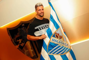 Fran Sol, posando con la bandera del Málaga.