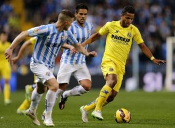 Giovani Dos Santos lucha el balón ante los jugadores del Málaga.