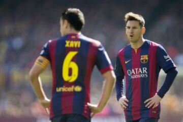 Leo Messi habla con su compañero Xavi Hernández.