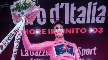 Team Ineos rider Italy's Filippo Ganna, wearing the overall leader's pink jersey, celebrates on the podium after winning the first stage of the Giro d'Italia 2020 cycling race, a 15.1-kilometer individual time trial between Monreale and Palermo. (Photo by