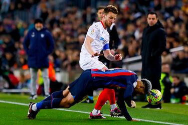 Ronald Araujo despeja el balón con la cabeza ante la oposición de Ivan Rakitic.