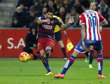 El delantero uruguayo del FC Barcelona Luis Suarez lanza a puerta, junto a Omar Mascarell, del Sporting de Gijón, para conseguir el tercer gol de su equipo.