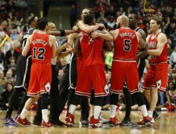 Noah abraza a su compañero Butler en plena trifulca con Joe Johnson.