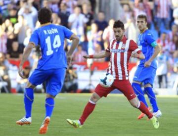 El delantero del Atlético de Madrid David Villa (2d) intenta controlar el balón ante el centrocampista del Getafe Pedro León (i), en el partido de la trigésima tercera jornada de liga de Primera División disputado esta tarde en el Coliseo Alfonso Pérez de Getafe.