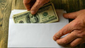 Billetes de cien dólares en un sobre.