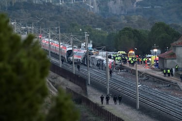Miembros de la Guardia Civil junto con otros efectivos de emergencia, trabajan junto a uno de los trenes implicados en el accidente, en el lugar del descarrilamiento mortal de dos trenes de alta velocidad cerca de Adamuz, en Córdoba.