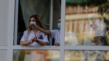Sanitarios aplauden desde una ventana de del Hospital Fundación Jiménez Díaz.