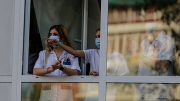 Sanitarios aplauden desde una ventana de del Hospital Fundaci&oacute;n Jim&eacute;nez D&iacute;az.