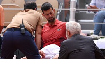 Serbia's Novak Djokovic receives medical treatment after he lost the third set during his men's singles round of sixteen match against Argentina's Francisco Cerundolo on Court Philippe-Chatrier on day nine of the French Open tennis tournament at the Roland Garros Complex in Paris on June 3, 2024. (Photo by Emmanuel Dunand / AFP)