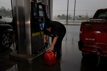 Una mujer llena un recipiente con gasolina mientras el huracán Helene se intensifica antes de tocar tierra en Big Bend, Florida.
