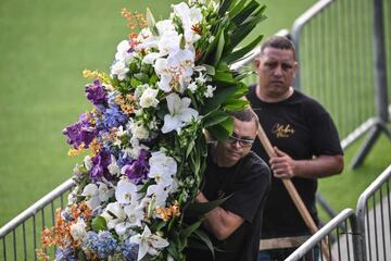 Operarios trasladan las numerosas flores que ha recibido el astro brasileño en su velatorio. 