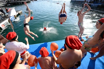 Los participantes saltan de manera acrobática al agua del puerto de Barcelona.