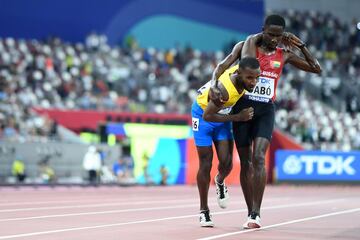 Braima Suncar Dabo de Guinea-Bissau ayuda a Jonathan Busby de Aruba a llegar a la meta durante las eliminatorias masculinas de 5000 metros en el Campeonato Mundial de Atletismo IAAF 2019 en el estadio Khalifa International en Doha el 27 de septiembre de 2019.