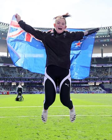 La medallista de bronce Holly Robinson de Nueva Zelanda posa para una foto con una bandera tras competir durante la final de lanzamiento de peso femenino F46. 