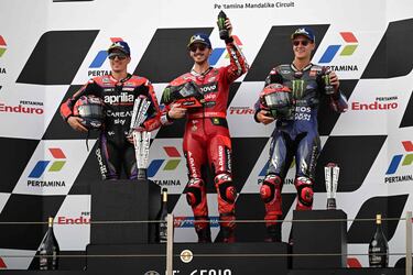 Francesco Bagnaia, en el centro de la imagen, celebra desde lo más alto del podio su triunfo en el GP de Indonesia, a su izquierda, el piloto español, Maverick Viñales, que acabó segudno, y a la derecha de Bagnaia, y el piloto francés , Fabio Quartararo, que acabó tercero.