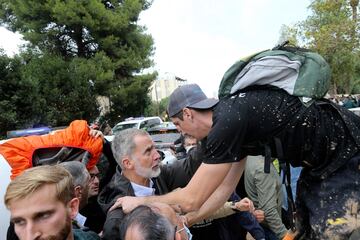 El rey Felipe VI de España escucha a una persona afectada por las inundaciones después de que una multitud de sobrevivientes enojados de las inundaciones de España arrojaran barro y gritaran insultos al rey.