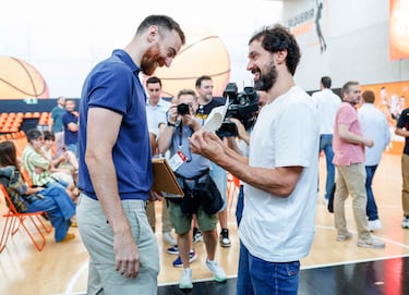 Víctor Claver mira fijamente el papel que le muestra su compañero y amigo Sergio Llull. Víctor Claver mira fijamente el papel que le muestra su compañero y amigo Sergio Llull.